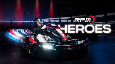 Two go karts on a go kart track with a rider waiving at the camera and the text RPM Heroes imposed over.