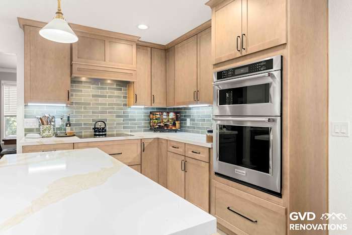 Remodeled kitchen with natural maple Shaker cabinets, sage green glass subway tile backsplash, stainless steel built-in wall oven and a Calacatta quartz island in Rescue, CA