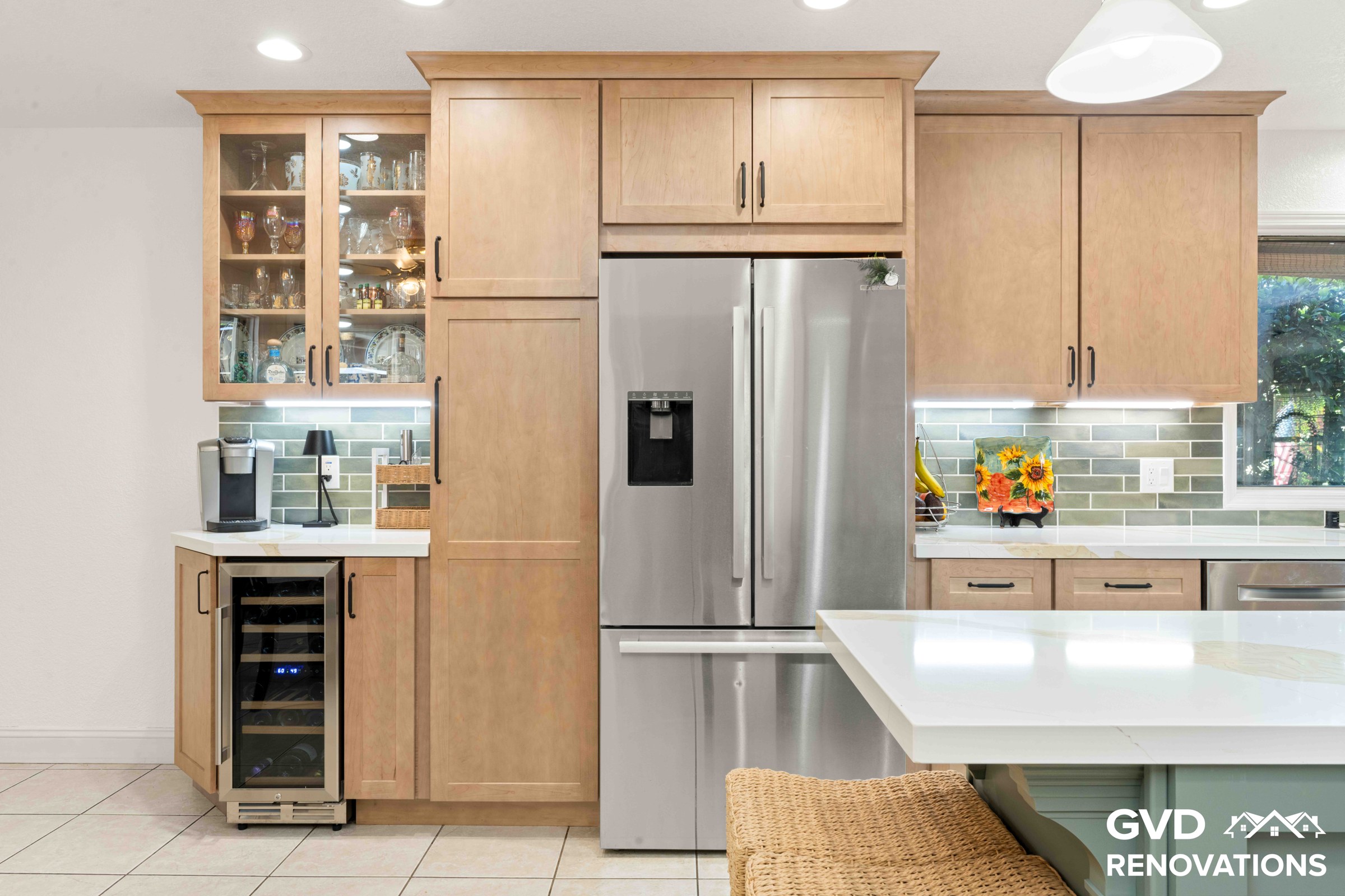 Coffee station with glass-front upper cabinets and a built-in wine fridge beside a stainless steel French-door refrigerator