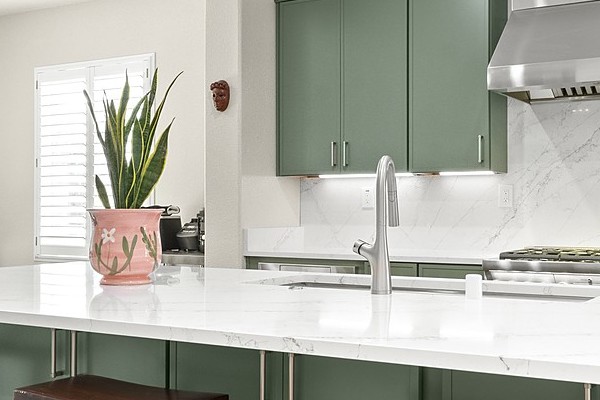 Bright kitchen with a quartz island, counter seating and an adjoining breakfast nook