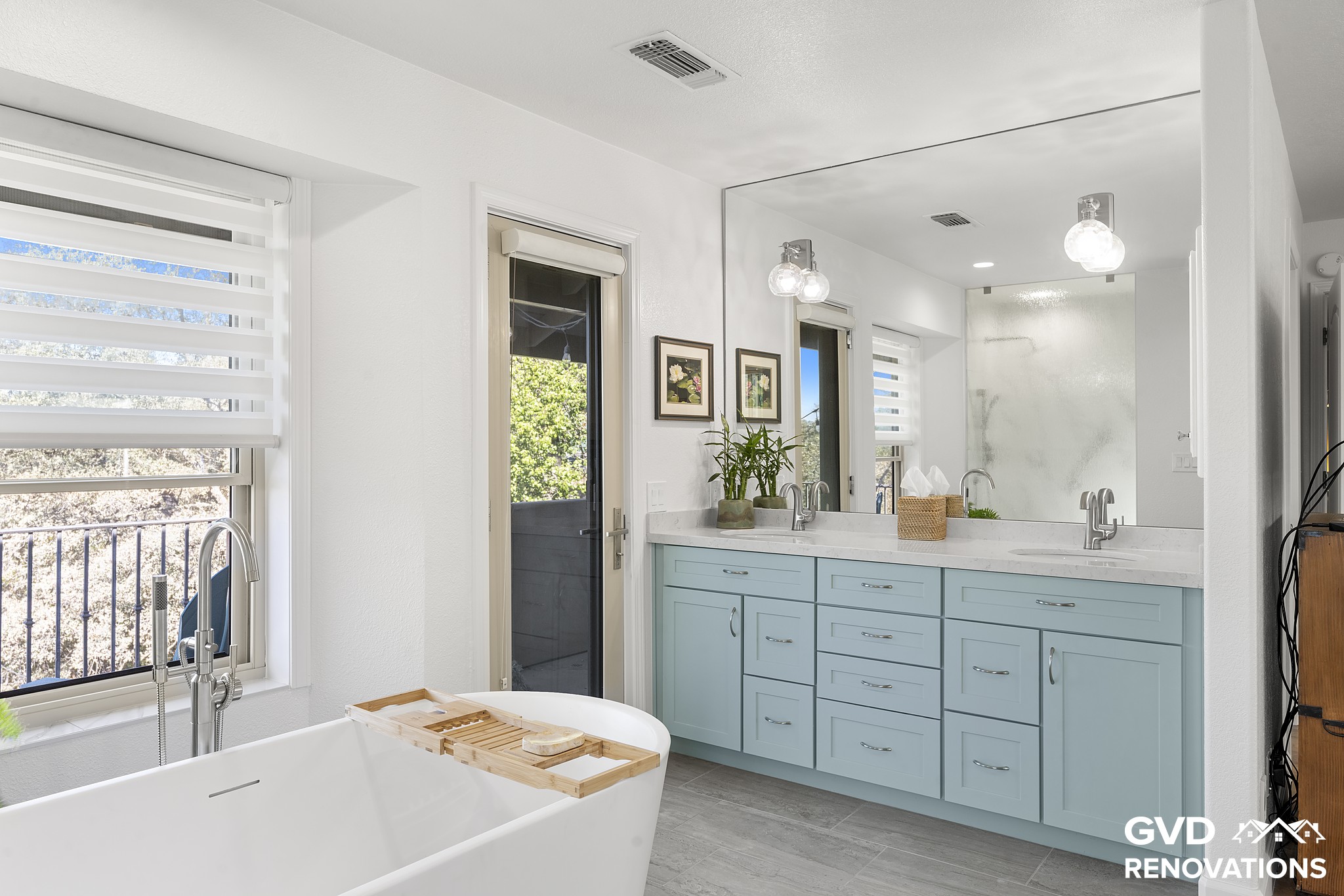 Sage-green double vanity with a quartz countertop and a large mirror beneath recessed lighting