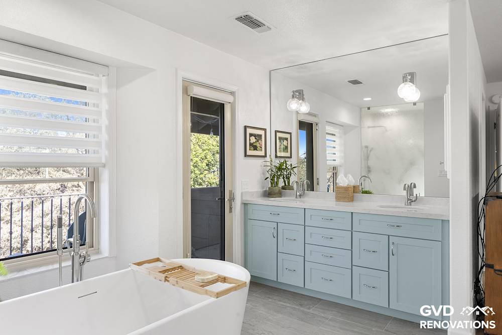 Sage-green double vanity with a quartz countertop and a large mirror beneath recessed lighting