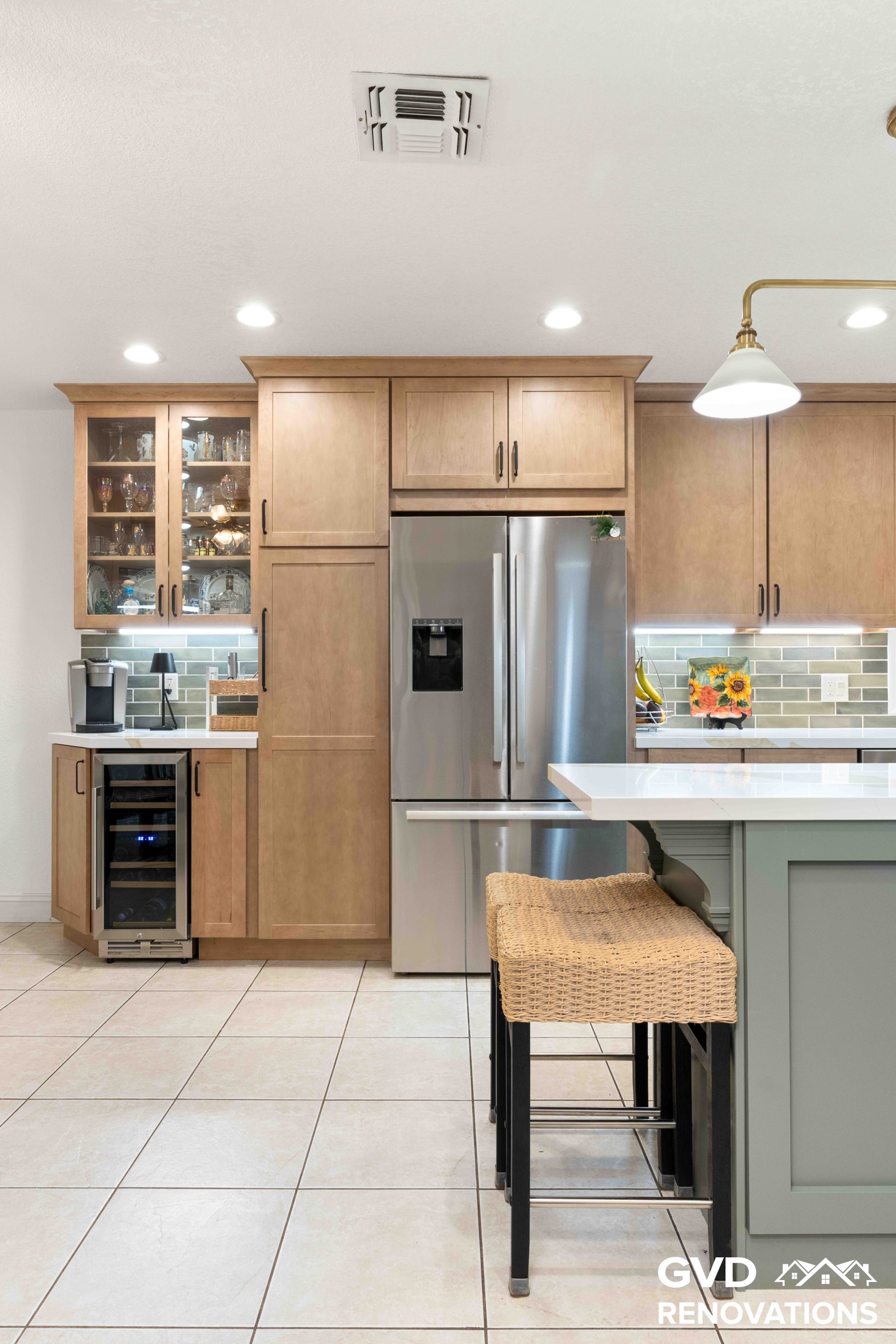 Coffee bar with glass-front cabinets beside the kitchen island with counter seating