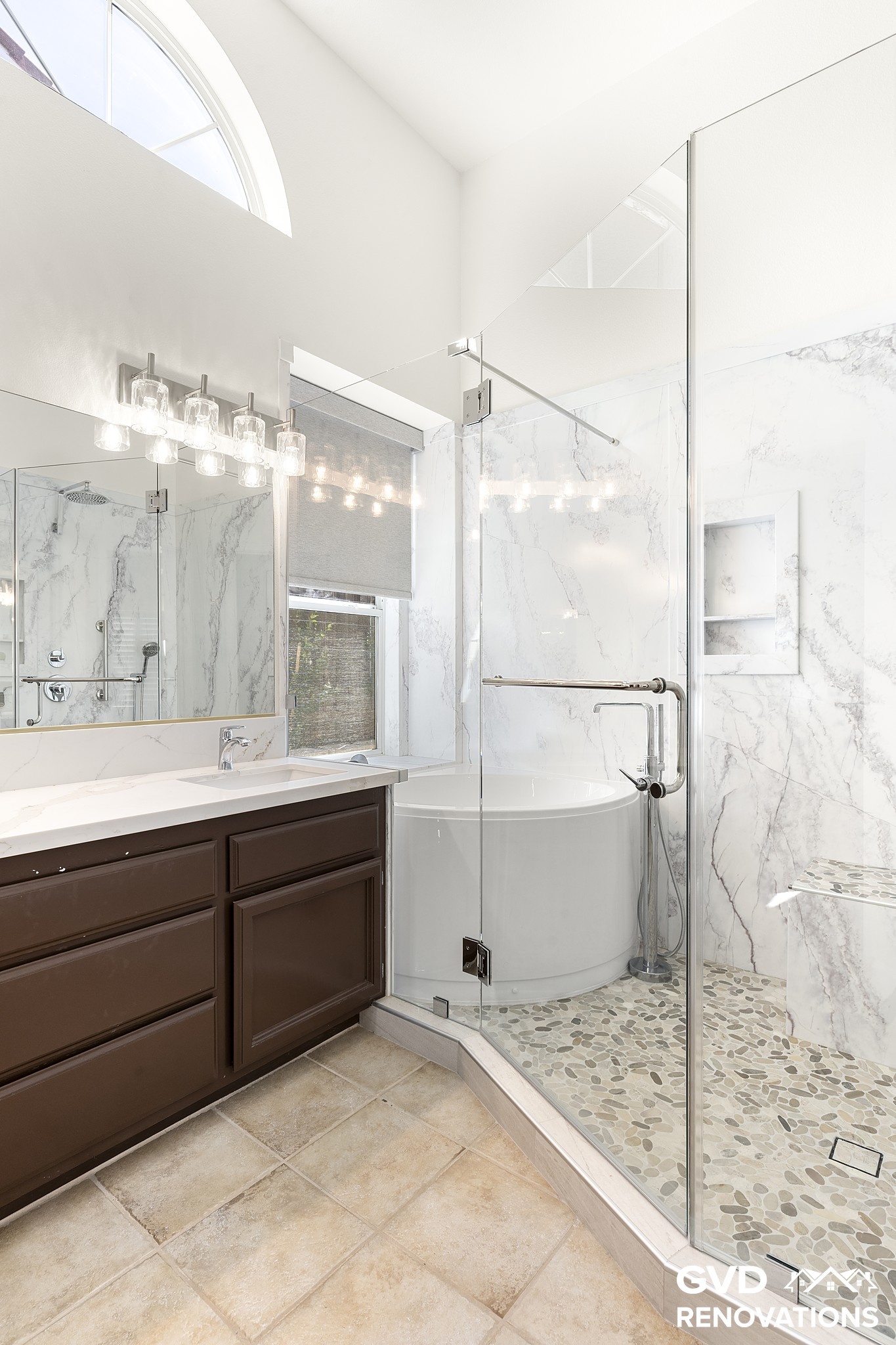 Double vanity with framed mirrors beside the marble-look walk-in shower