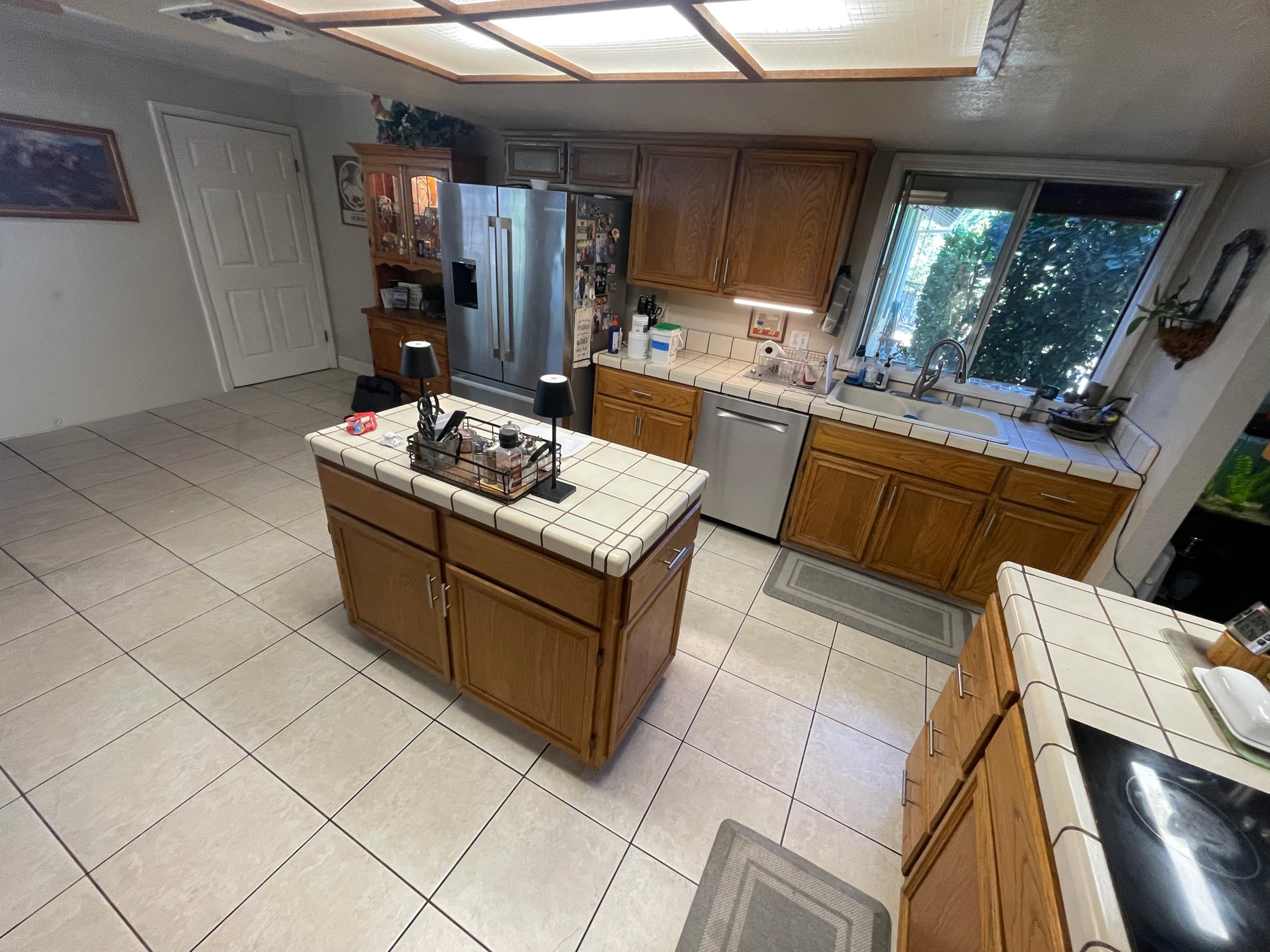 Before: original kitchen with oak cabinets, a tile island and tile countertops