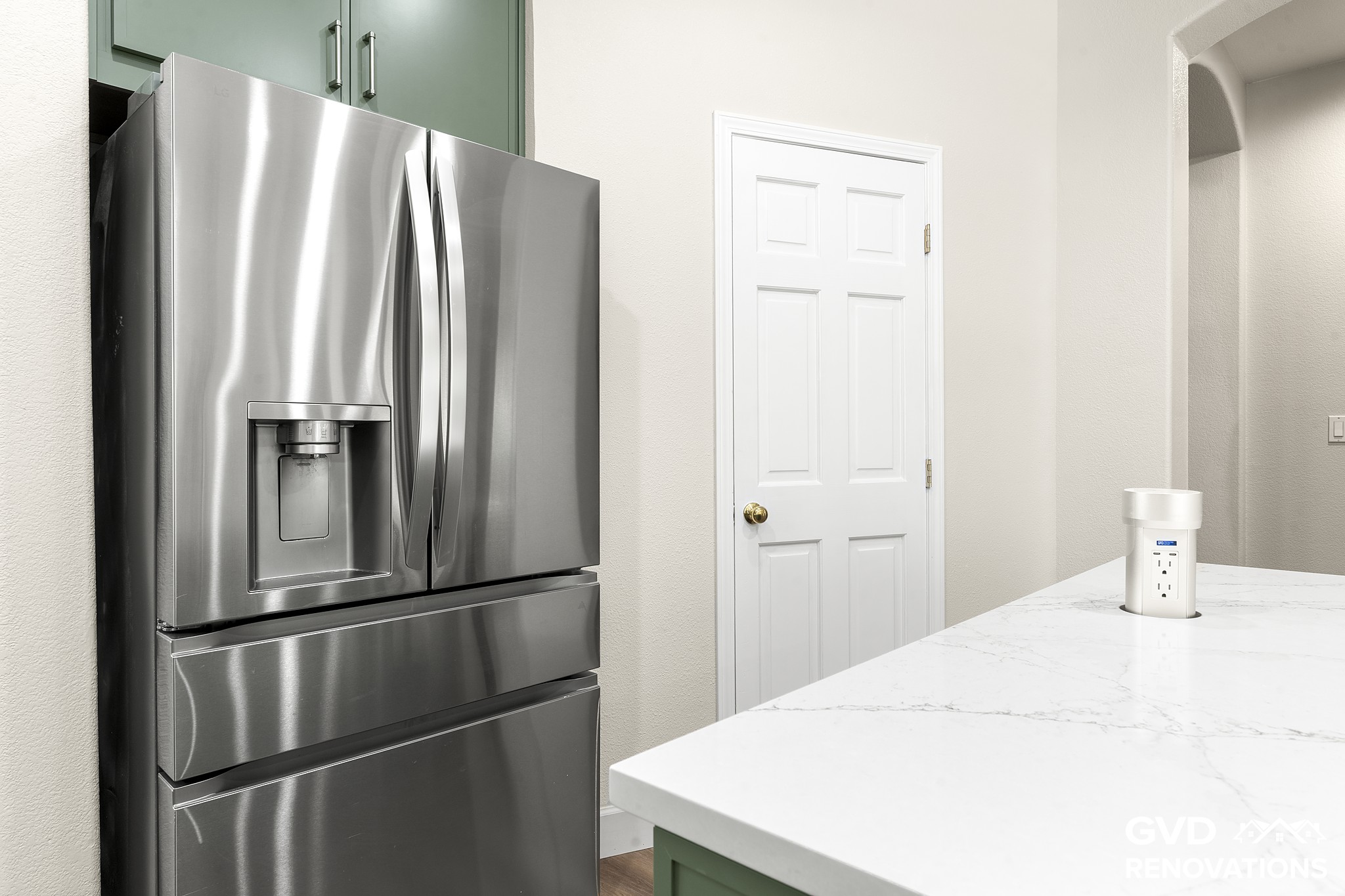 Stainless French-door refrigerator beside a built-in pantry in a sage green kitchen