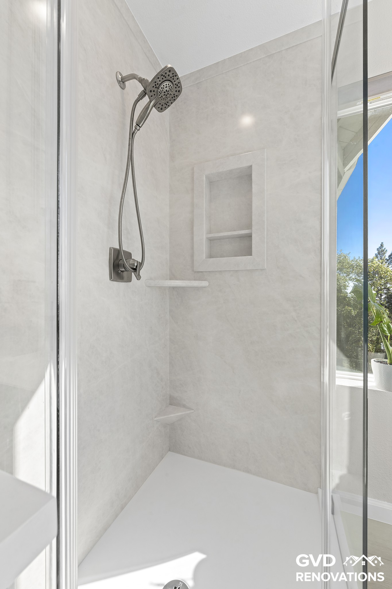 Marble-look shower interior with a recessed niche and matte-black fixtures