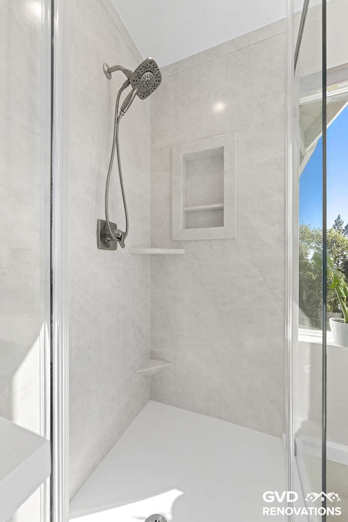 Marble-look shower interior with a recessed niche and matte-black fixtures