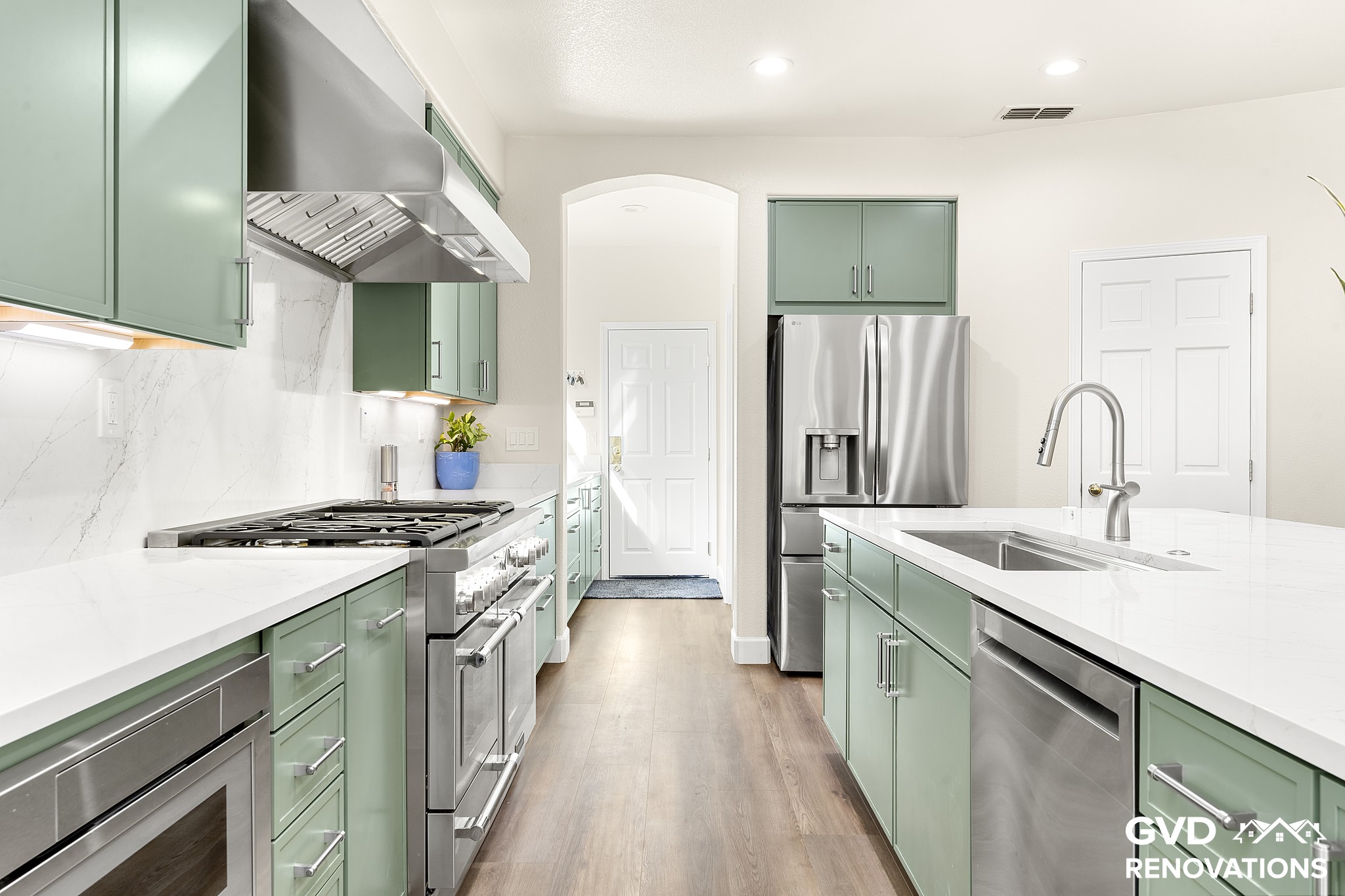 Kitchen sink wall with a stainless dishwasher and French-door refrigerator beside the island