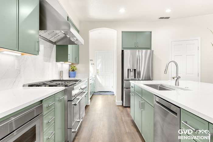 Kitchen sink wall with a stainless dishwasher and French-door refrigerator beside the island
