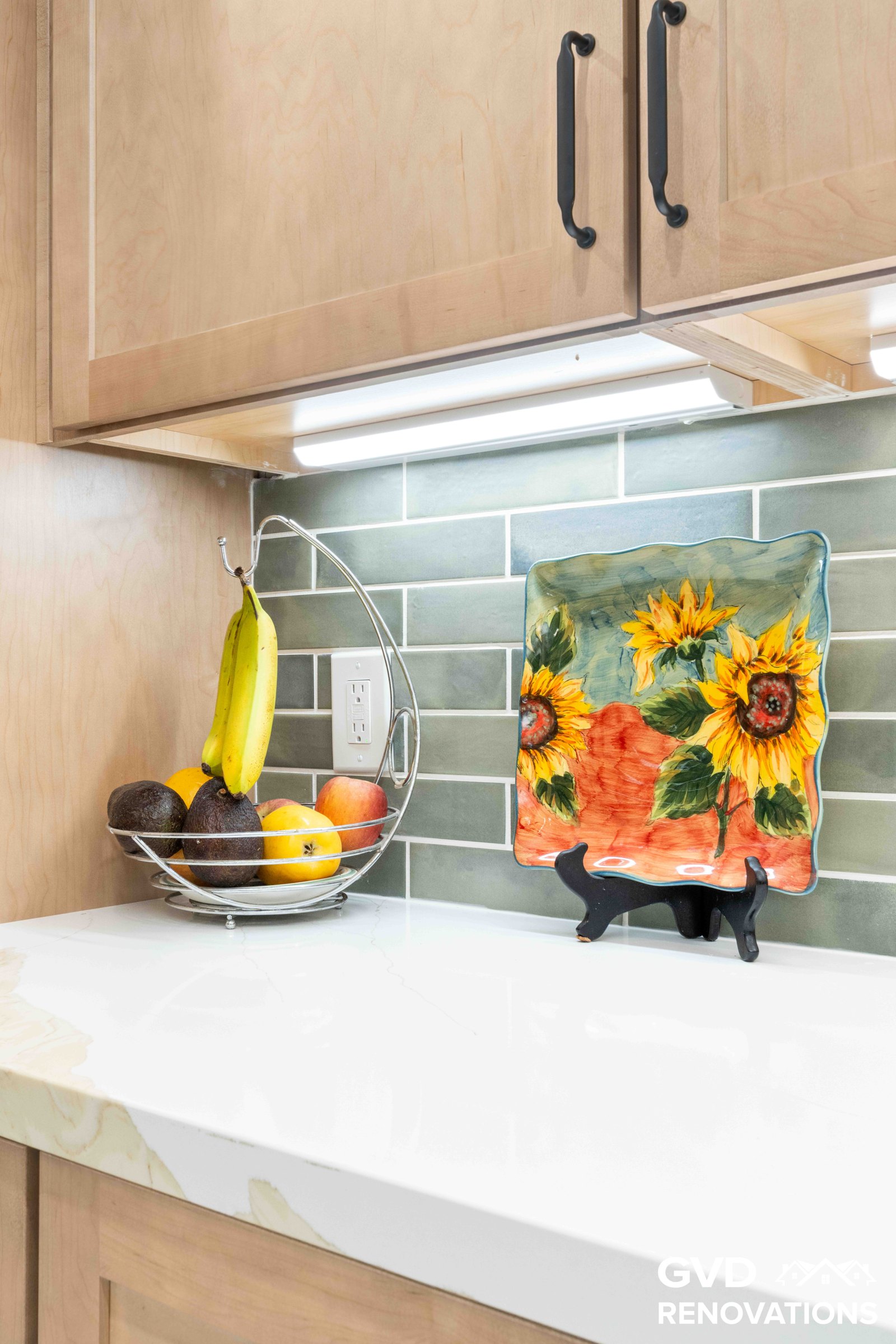 Styled quartz countertop with decorative sunflower backsplash art and a green subway tile backsplash