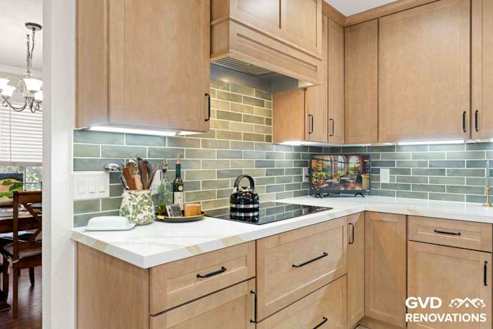 Open-concept kitchen looking toward the dining area, with a cooktop peninsula, maple cabinets and quartz counters
