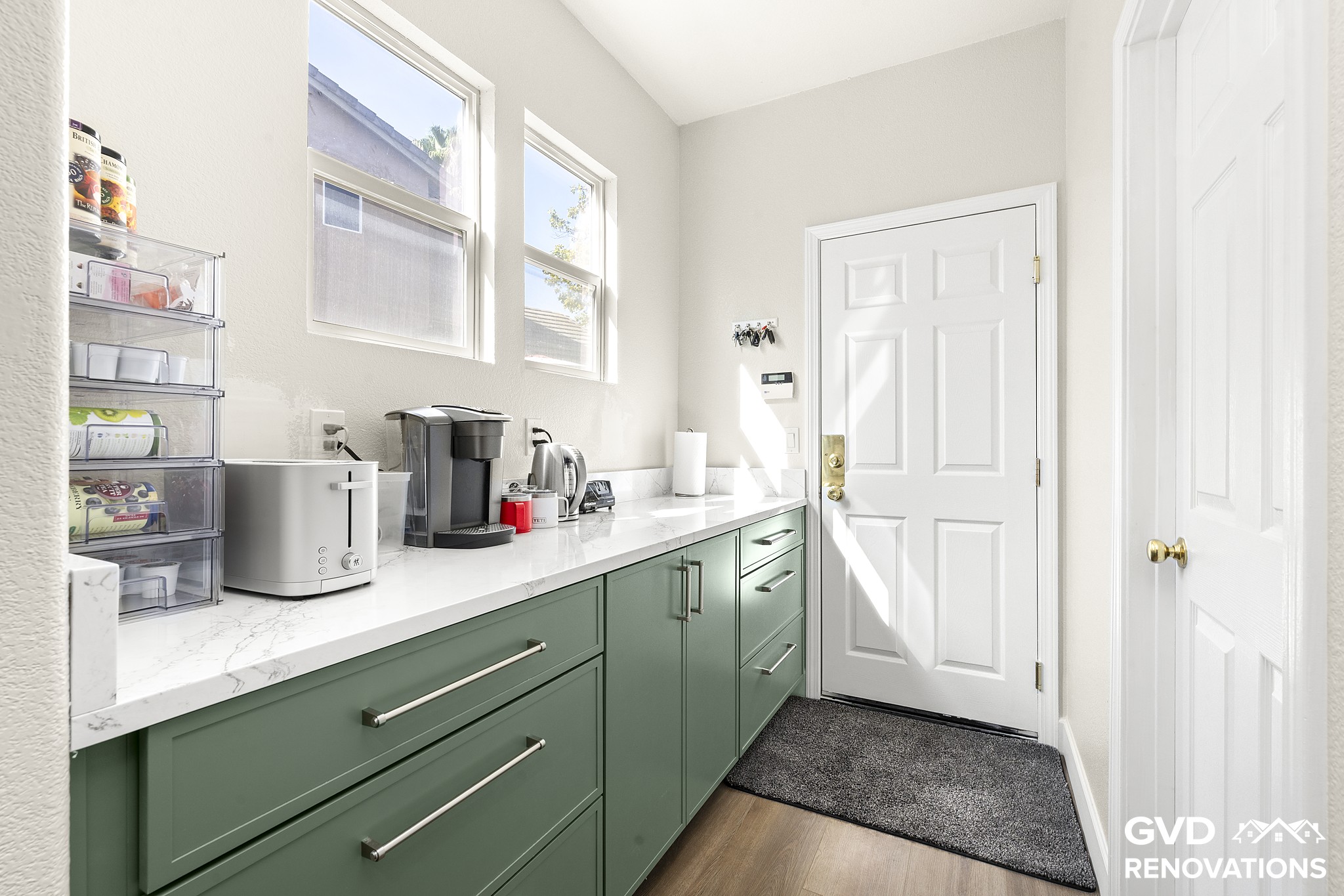 Coffee and beverage station with quartz counters below a window in the remodeled kitchen
