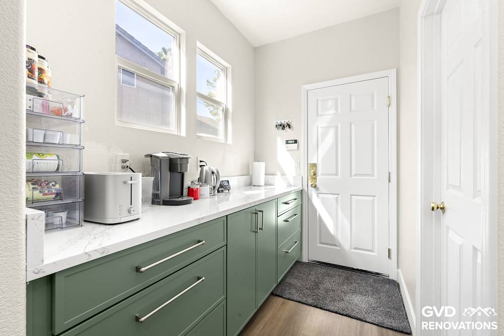 Coffee and beverage station with quartz counters below a window in the remodeled kitchen
