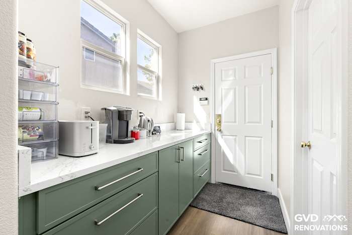 Coffee and beverage station with quartz counters below a window in the remodeled kitchen