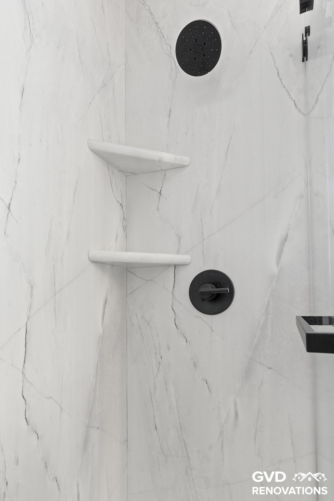 Walk-in shower with a recessed niche, corner shelves and matte-black fixtures