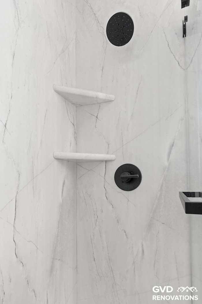 Walk-in shower with a recessed niche, corner shelves and matte-black fixtures