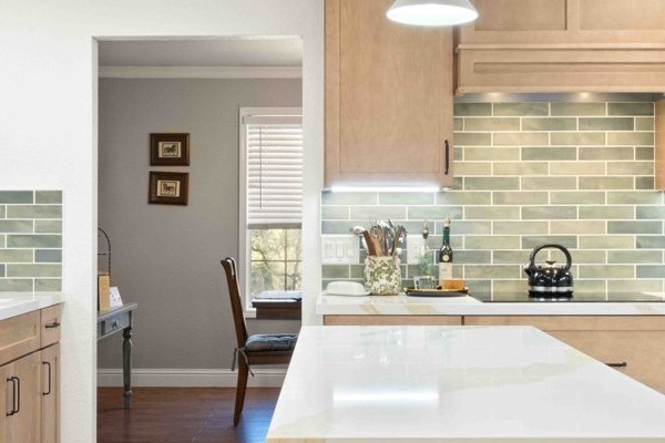 Remodeled open-concept kitchen with maple Shaker cabinets, a quartz center island and stainless steel appliances