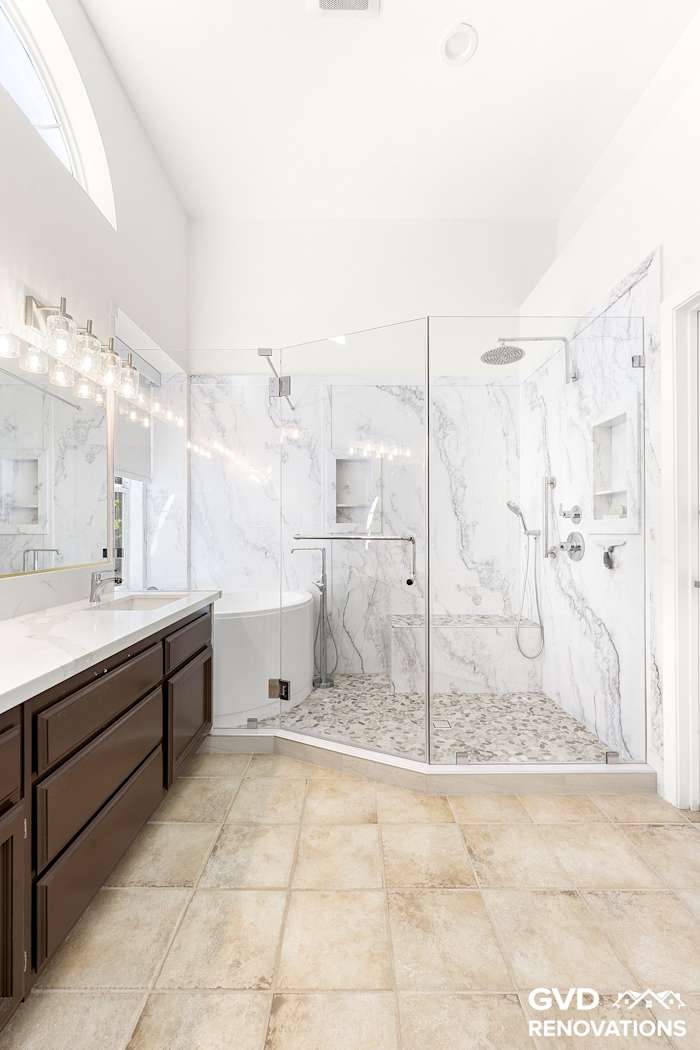 Wide view of the remodeled master bathroom with a double vanity, soaking tub and walk-in shower