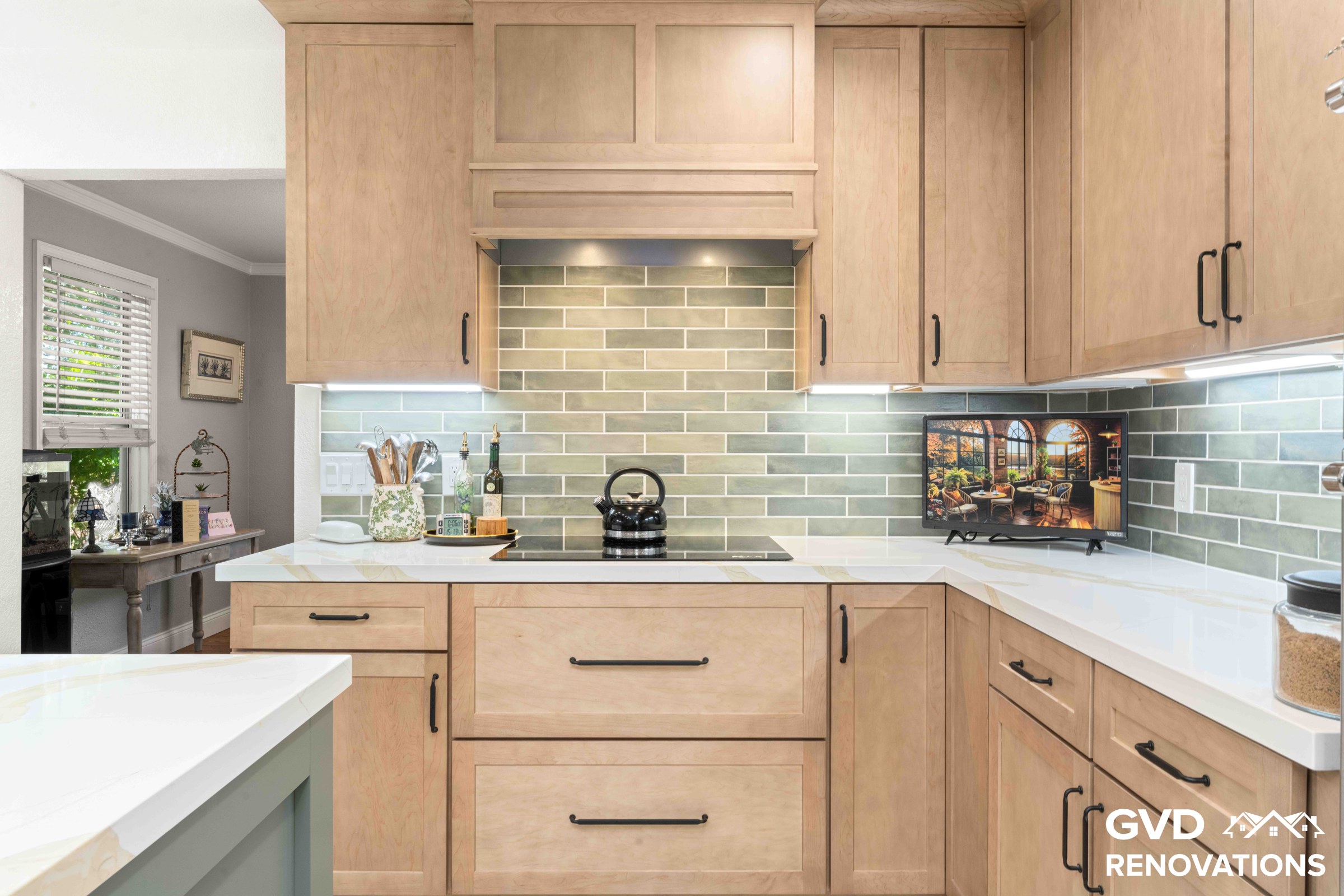 Kitchen cooktop wall with a custom wood range hood, green glass subway tile backsplash, quartz counters and maple cabinetry