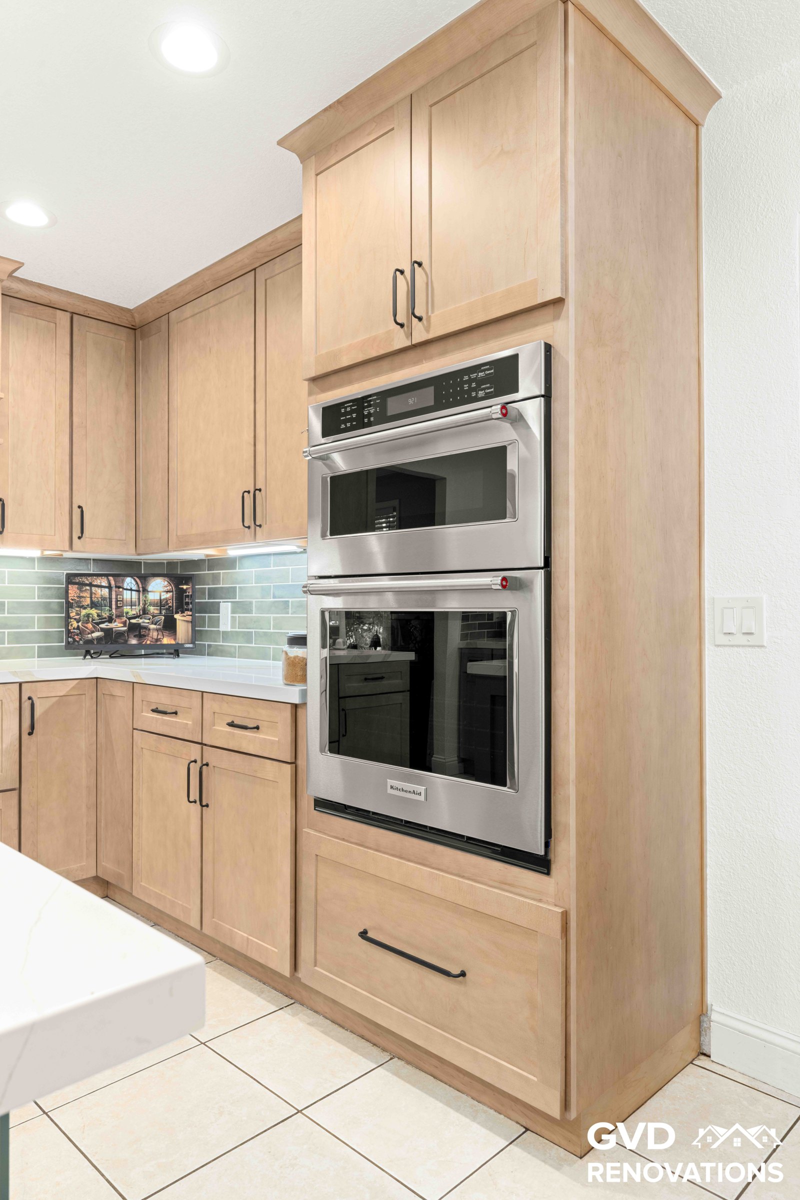 Stainless steel double wall oven column set in maple Shaker cabinetry with quartz counters