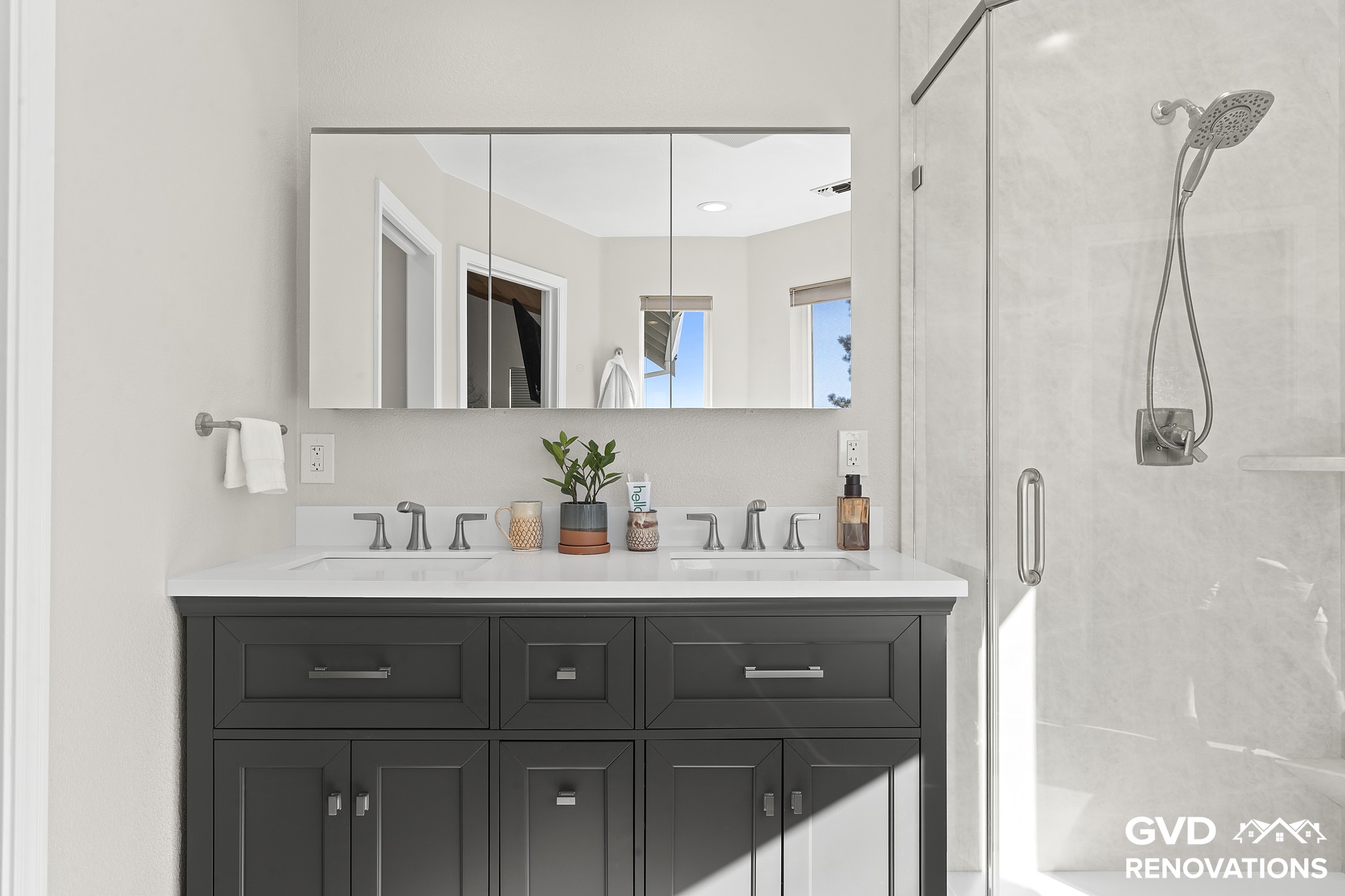 Charcoal double vanity with a quartz countertop and a frameless glass neo-angle shower