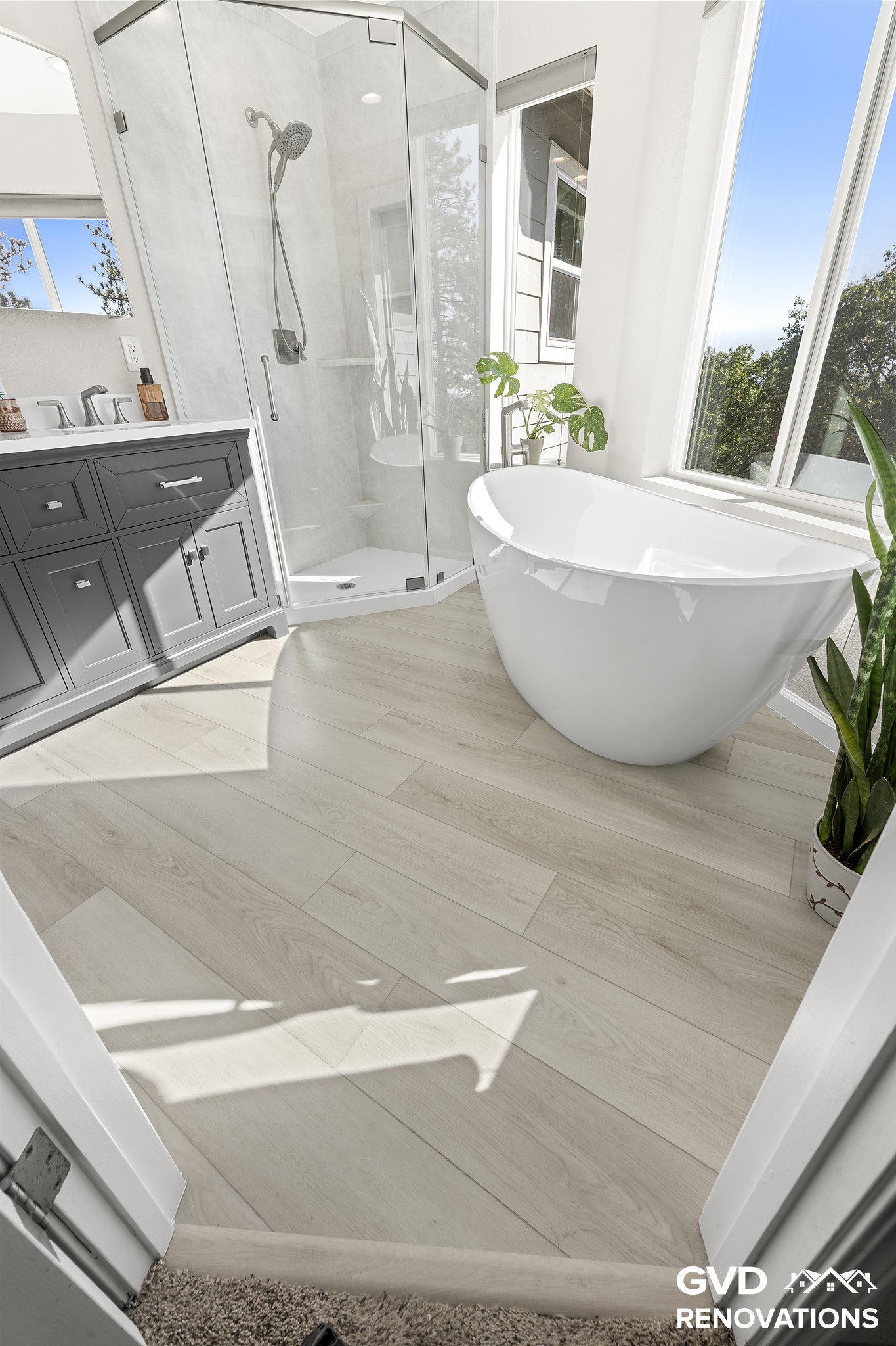 Entry to the marble-look walk-in shower with wood-look flooring