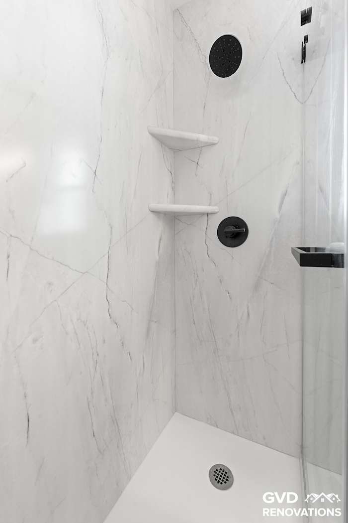 Marble-look shower interior with a recessed niche and a corner shelf