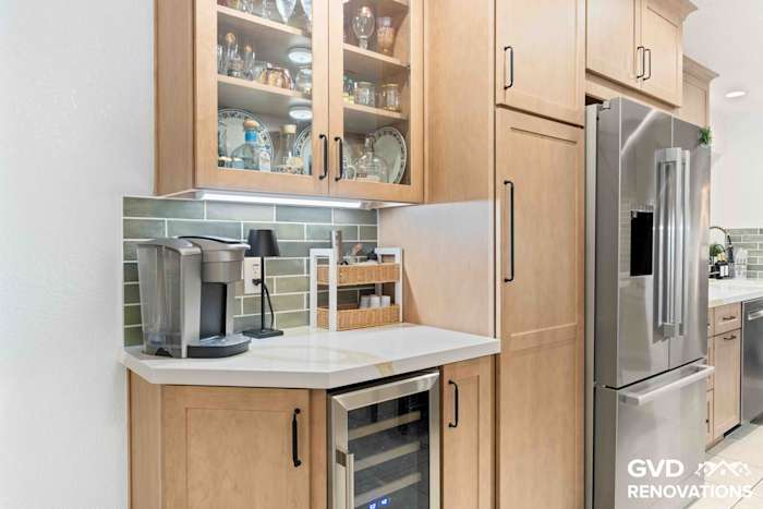 Kitchen coffee and beverage station with glass-front maple Shaker cabinets, Calacatta quartz countertop, built-in wine refrigerator and stainless steel French-door refrigerator