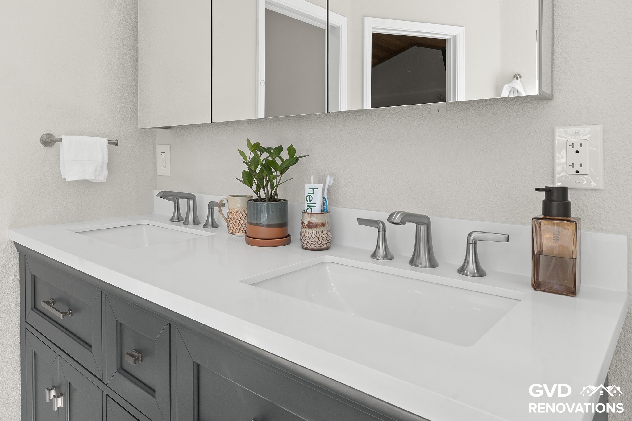 Charcoal double vanity with matte-black faucets and a quartz countertop