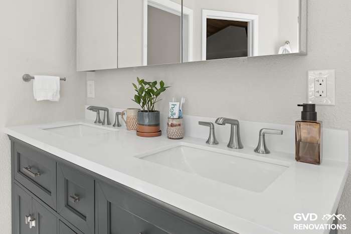 Charcoal double vanity with matte-black faucets and a quartz countertop