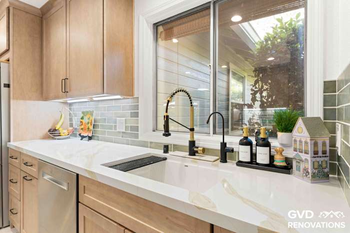 Kitchen prep area with a stainless dishwasher, undermount sink, window and green glass subway tile backsplash