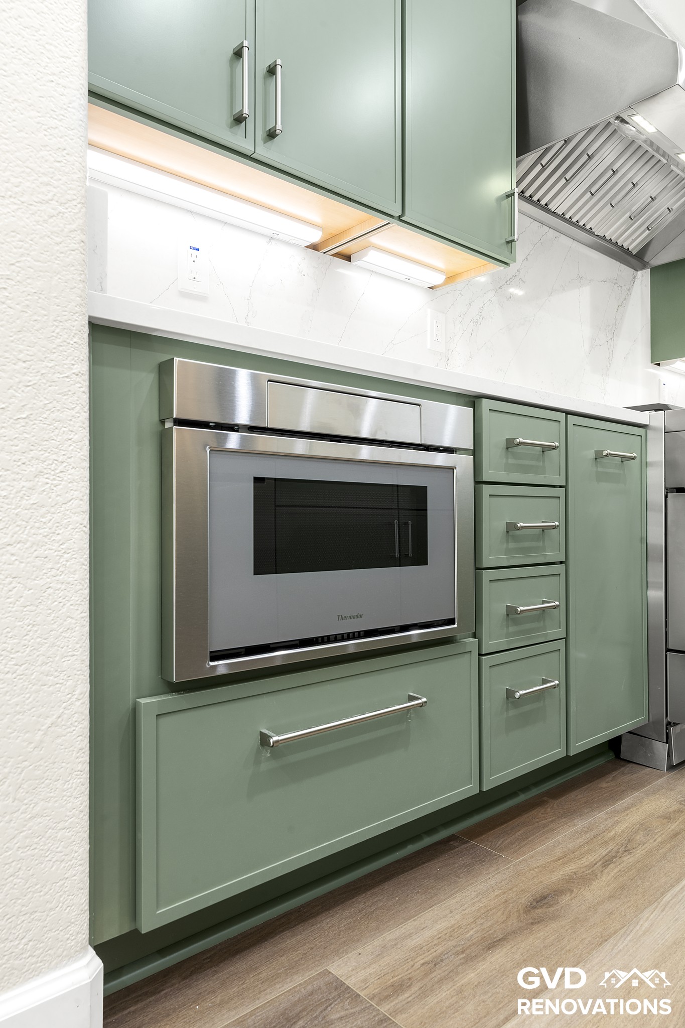 Built-in stainless wall oven and microwave column set in sage green cabinetry