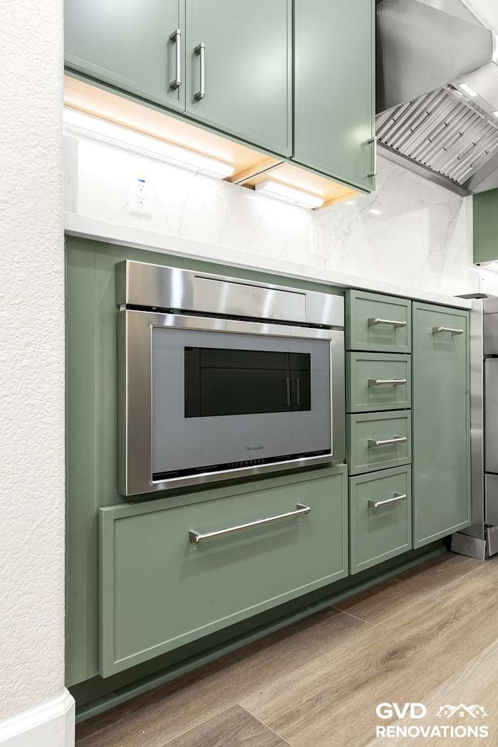 Built-in stainless wall oven and microwave column set in sage green cabinetry