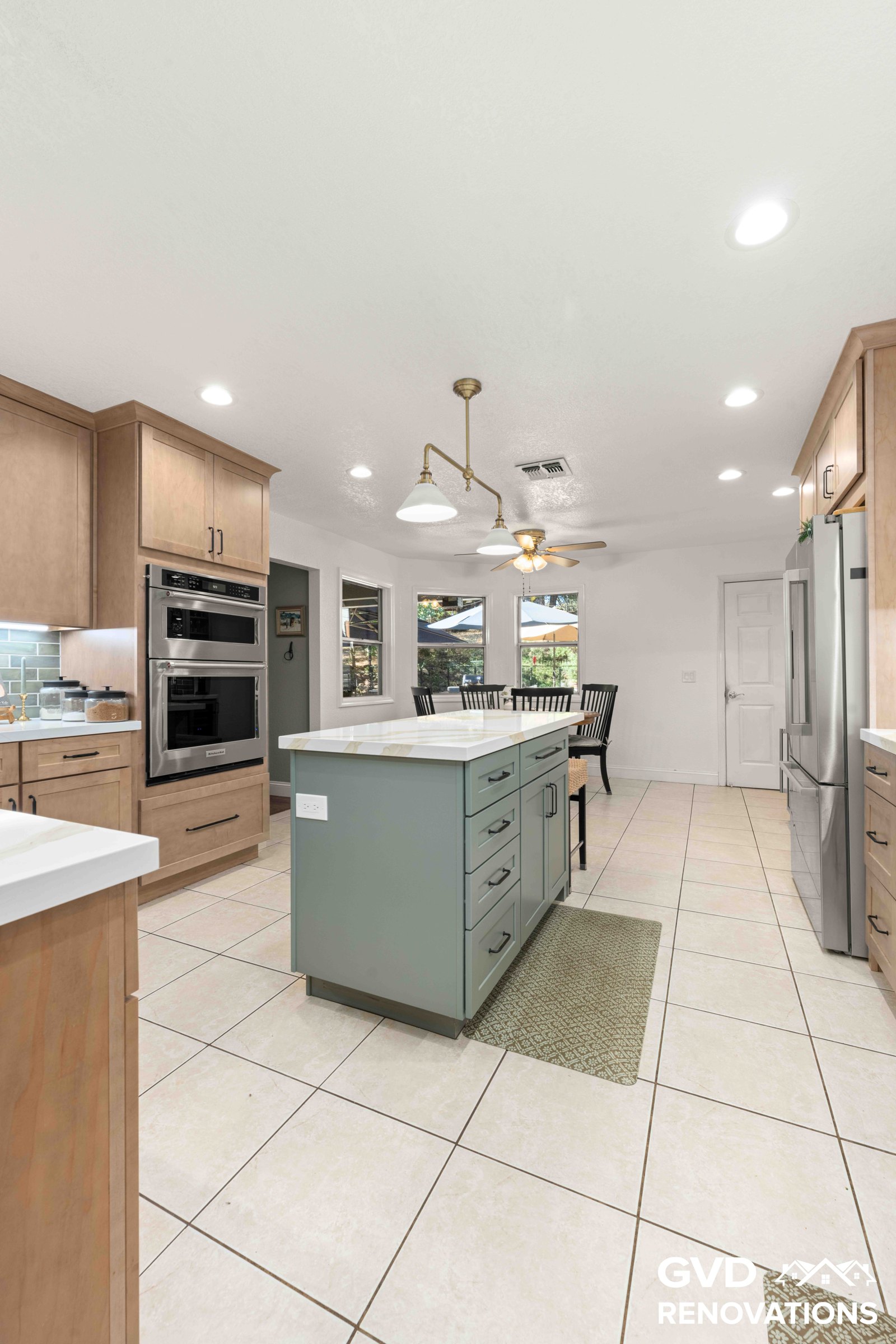Long view down the remodeled kitchen toward the breakfast nook with the island and pendant lighting