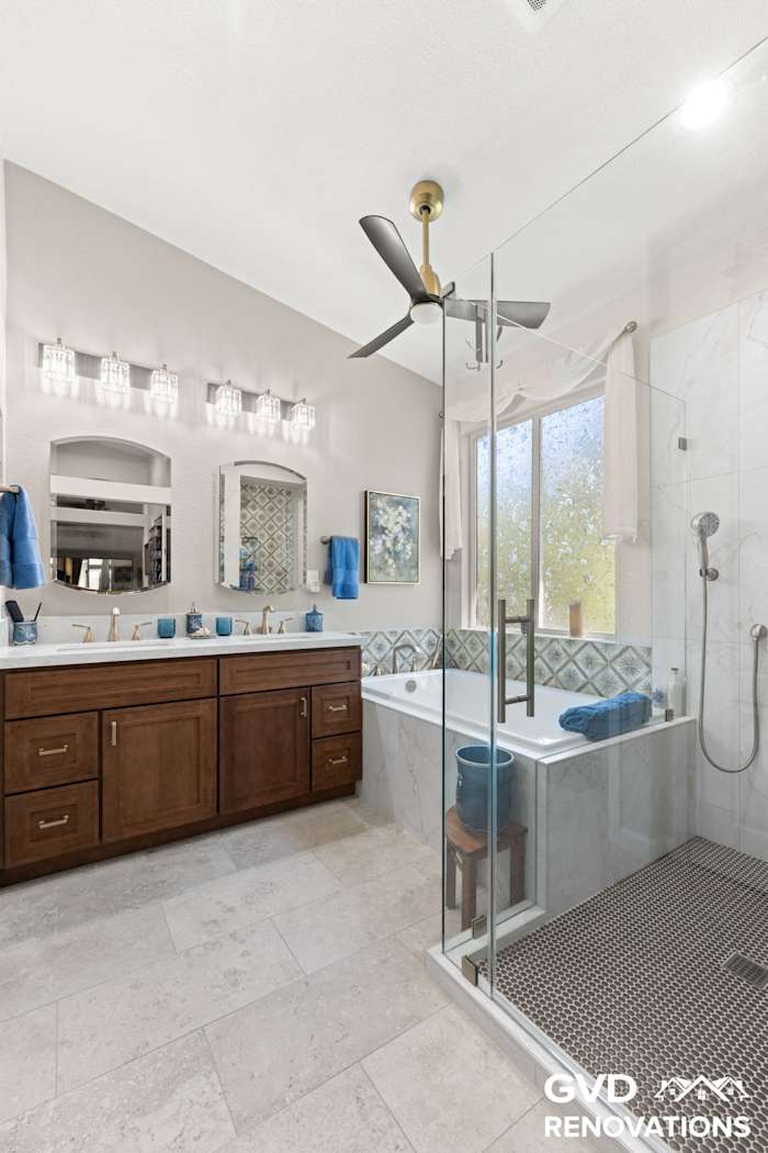 Double vanity and frameless glass shower with marble-look tile