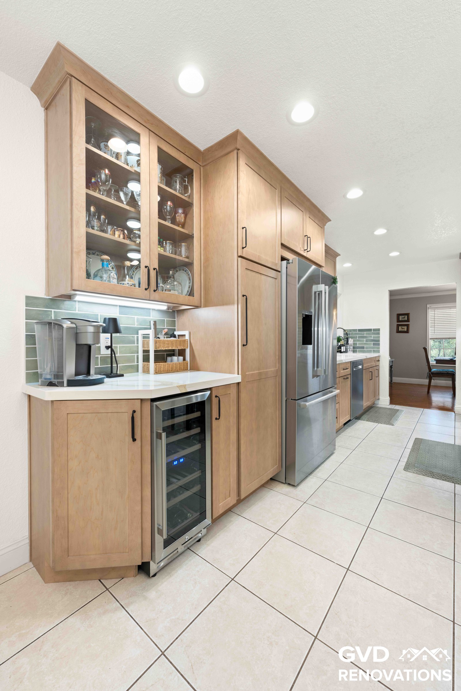 Beverage station with glass-front upper cabinets, a built-in wine fridge and a stainless French-door refrigerator