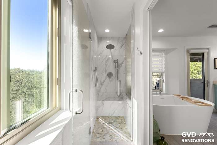 Walk-in shower with marble-look walls, a frameless glass enclosure and a forest-view window