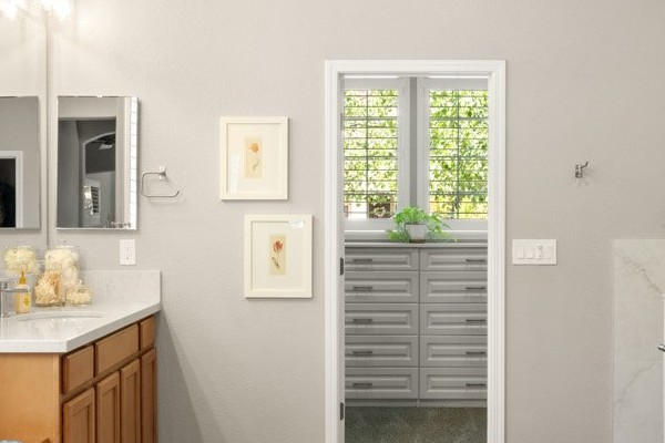 Remodeled master bathroom with a wood vanity, quartz countertop and a large marble-tiled walk-in shower