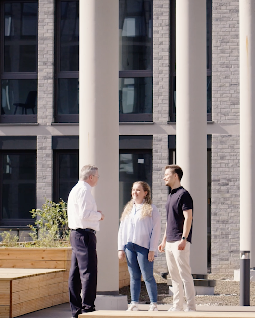 Case | DMK | Gallery 2 | Bild 3 Ingo Müller redet mit zwei jungen Menschen draußen vor einem Gebäude