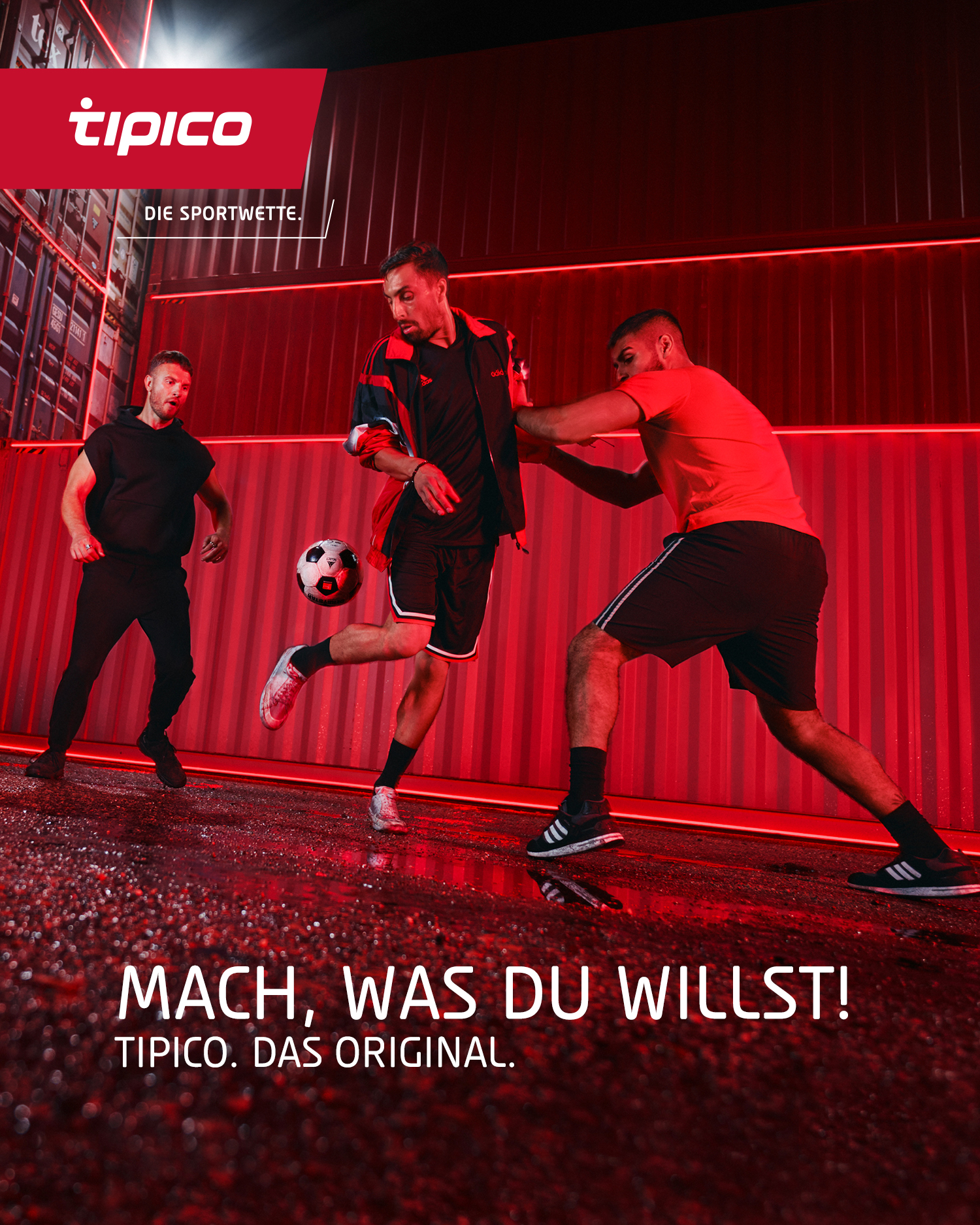 Ein rot getöntes Bild zeigt drei Männer die mit einem Ball spielen