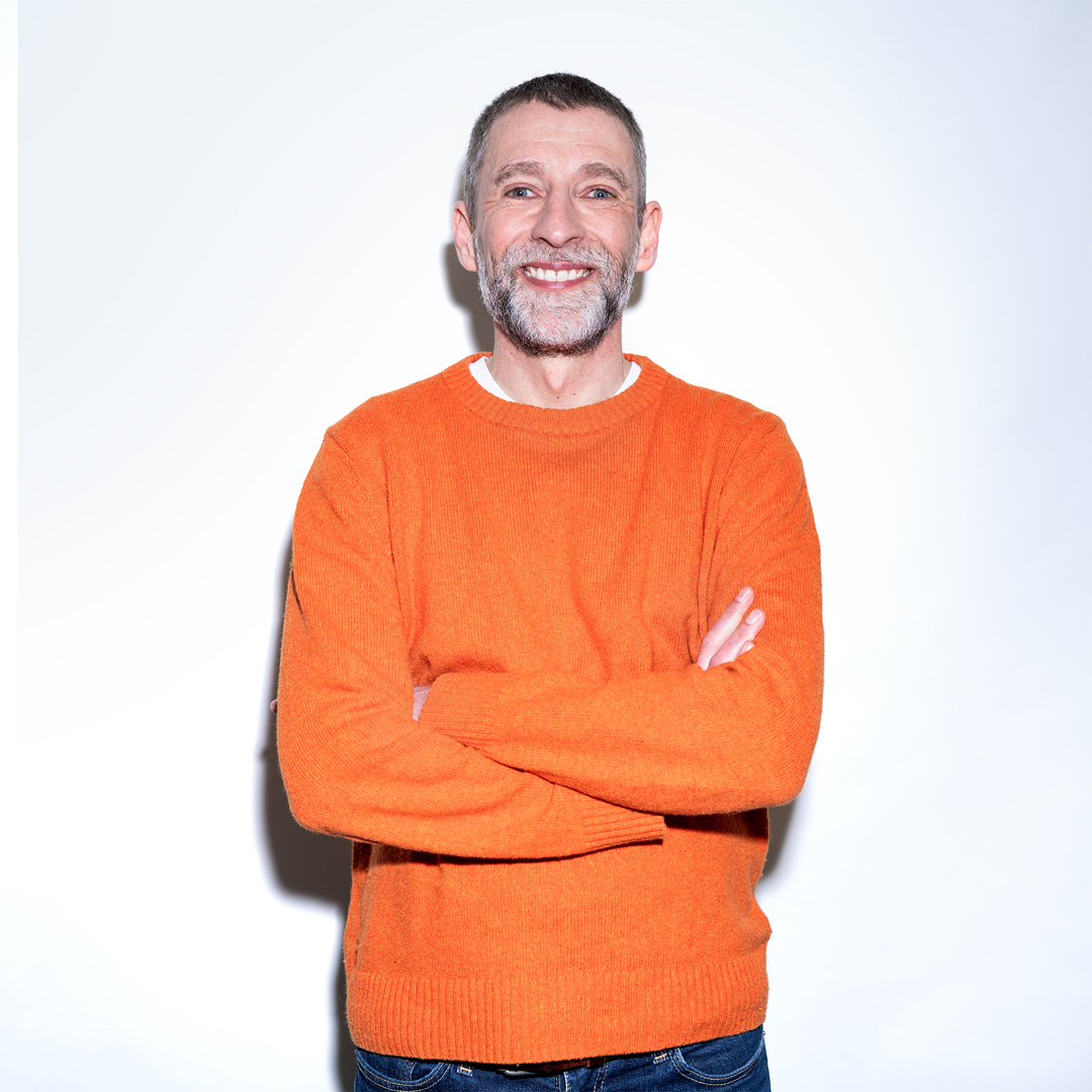 Christian Thron lächelt mit verschränkten Armen