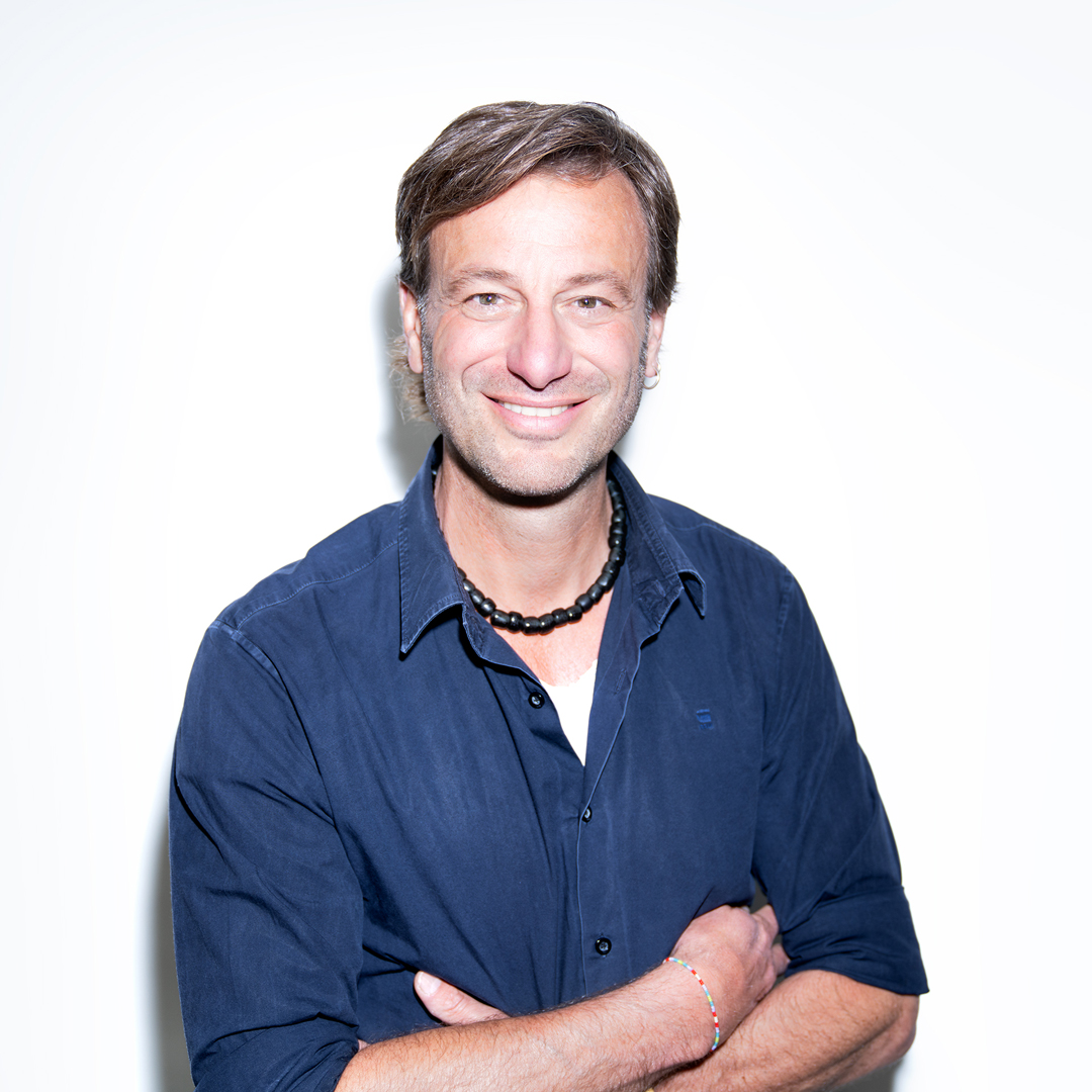 Florian Liebold lächelt mit verschränkten Armen