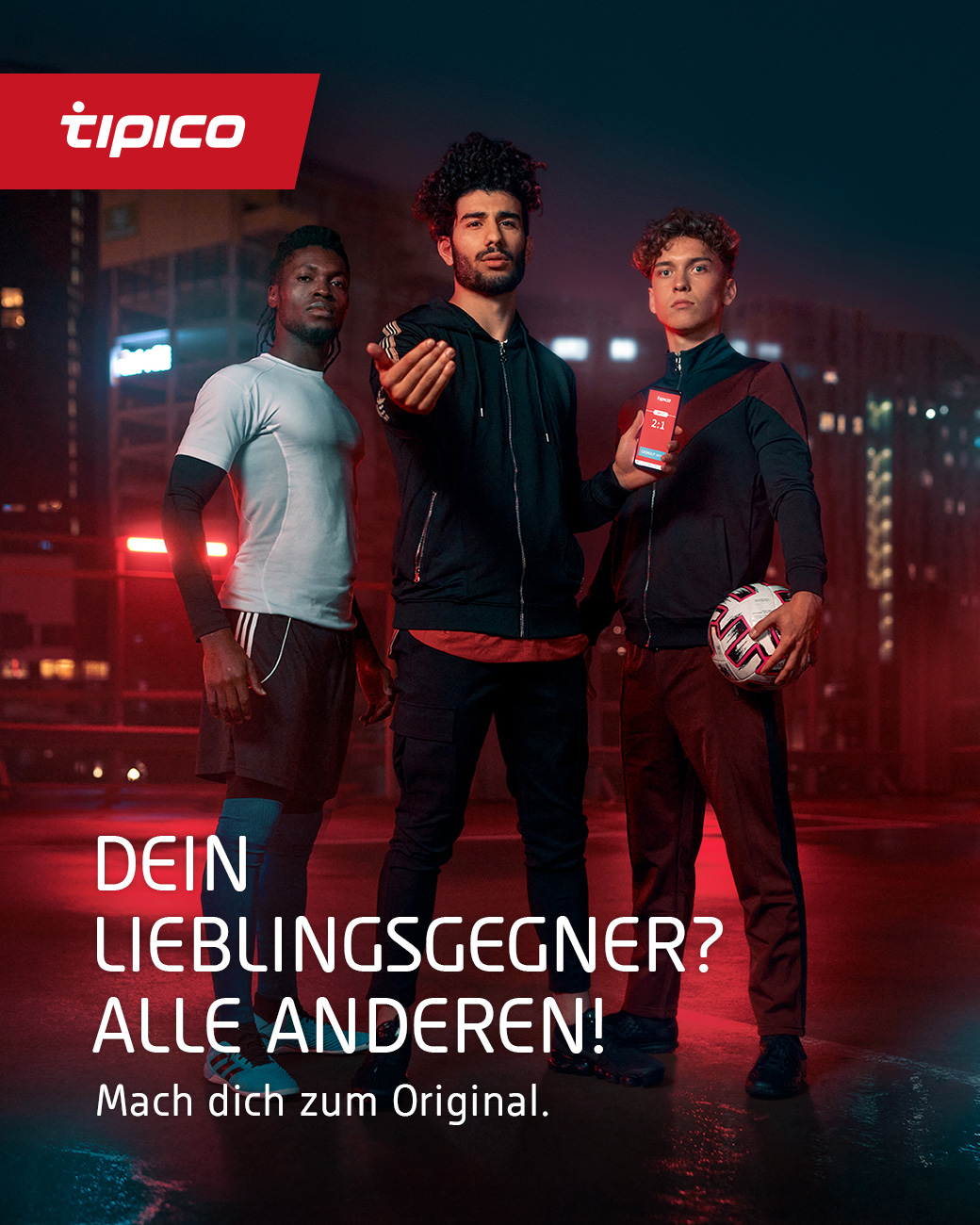 Drei junge Männer im Sportdress stehen vor einem dunklen Hintergrund der mit rotem Licht beleuchtet wird in weißer Schrift steht vor dem Bild „DEIN LIEBLINGSGEGNER? ALLE ANDEREN! Mach dich zum Original.“