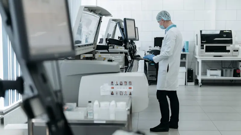 A man working at a research facility in a white coat.