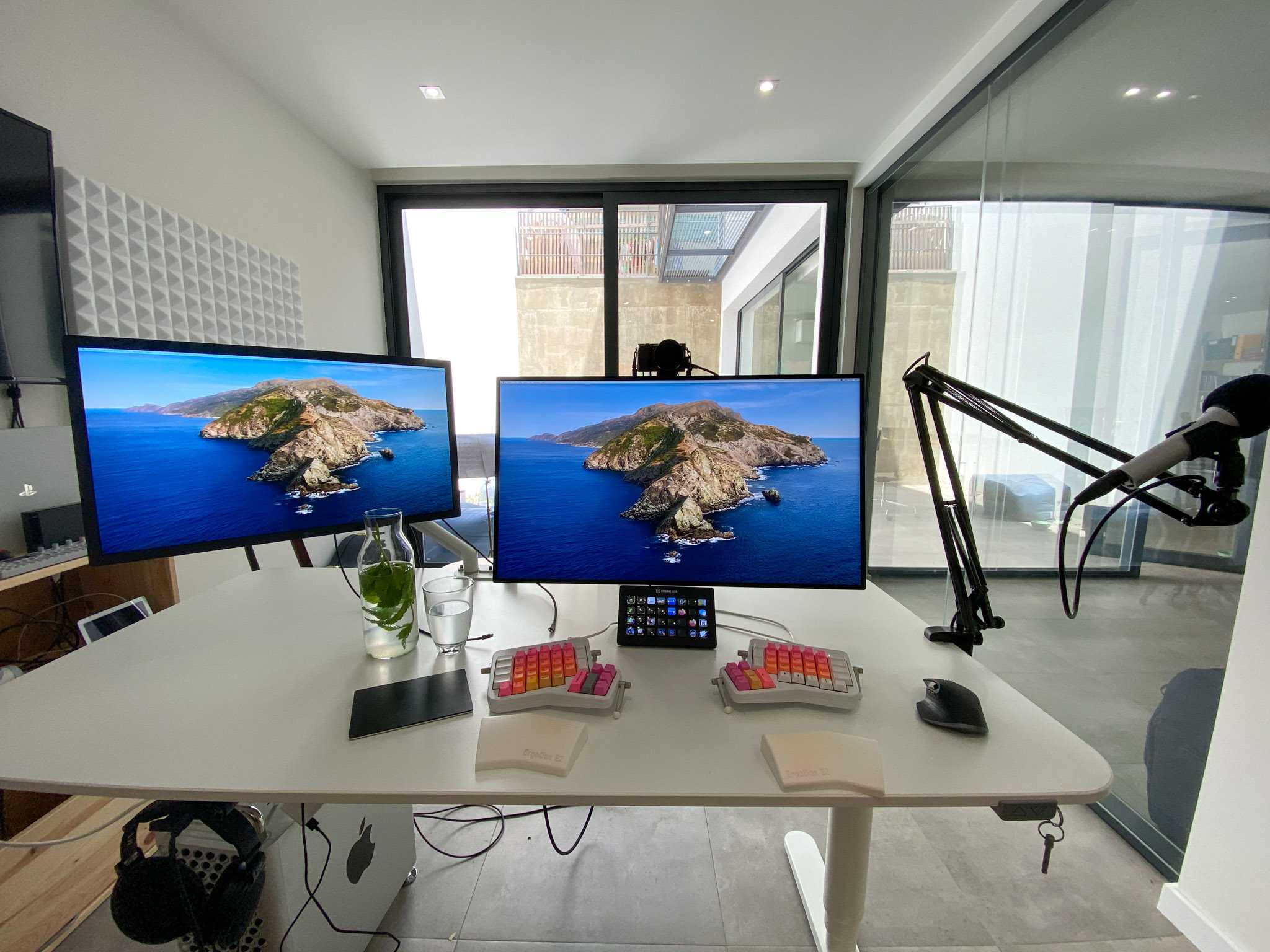 desk with keyboard, mouse, two monitors and microphone