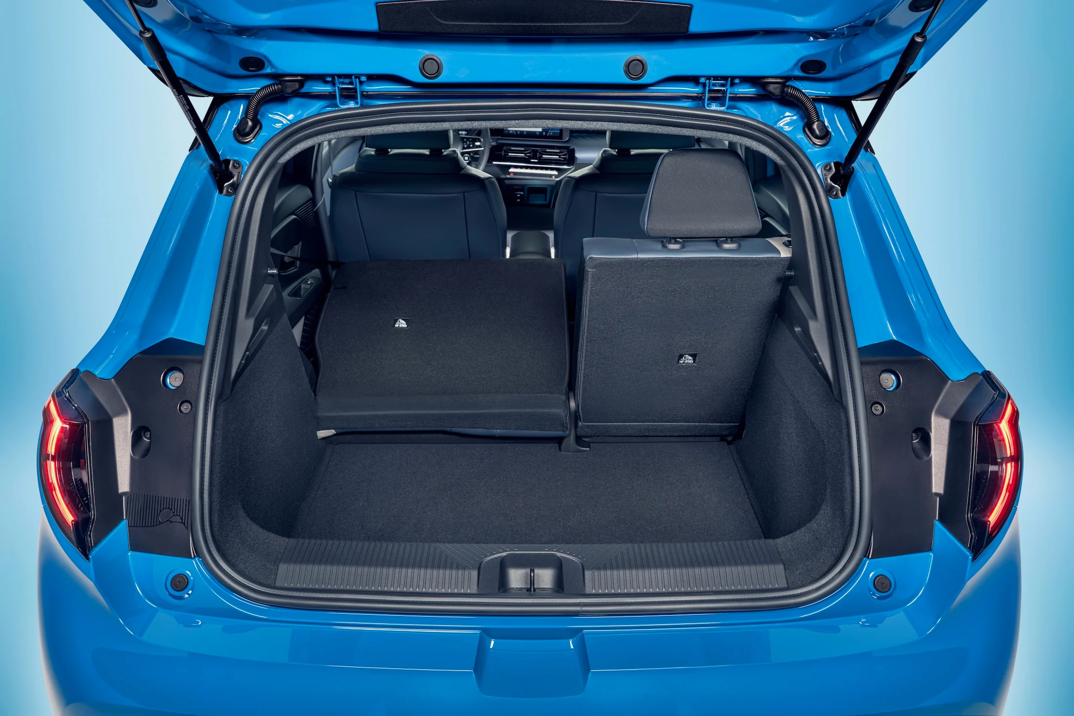 focused view of Micra-s empty trunk space with open trunk door and one collapsed seat