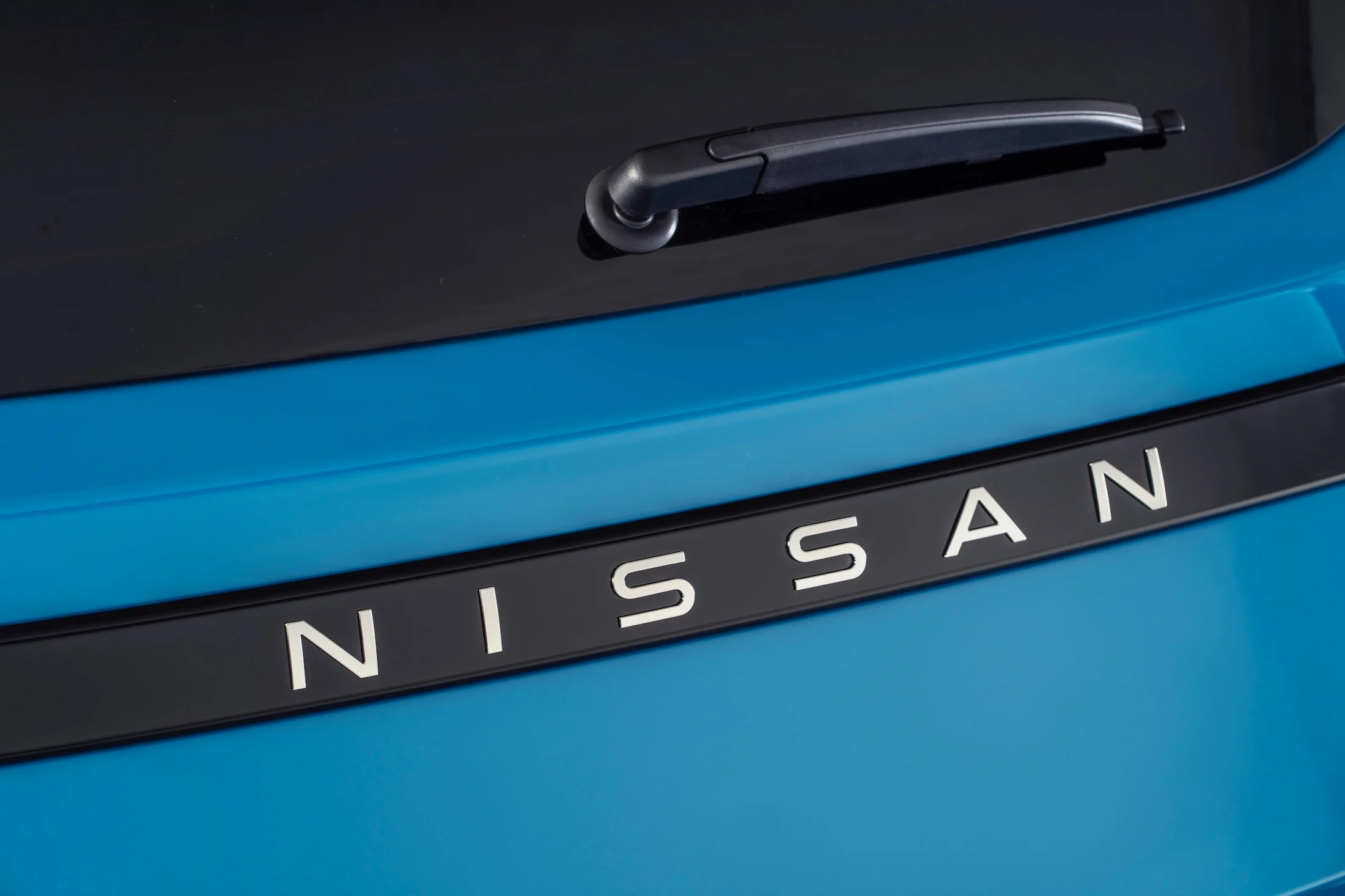 detailed image of NISSAN name plate on rear body of Micra
