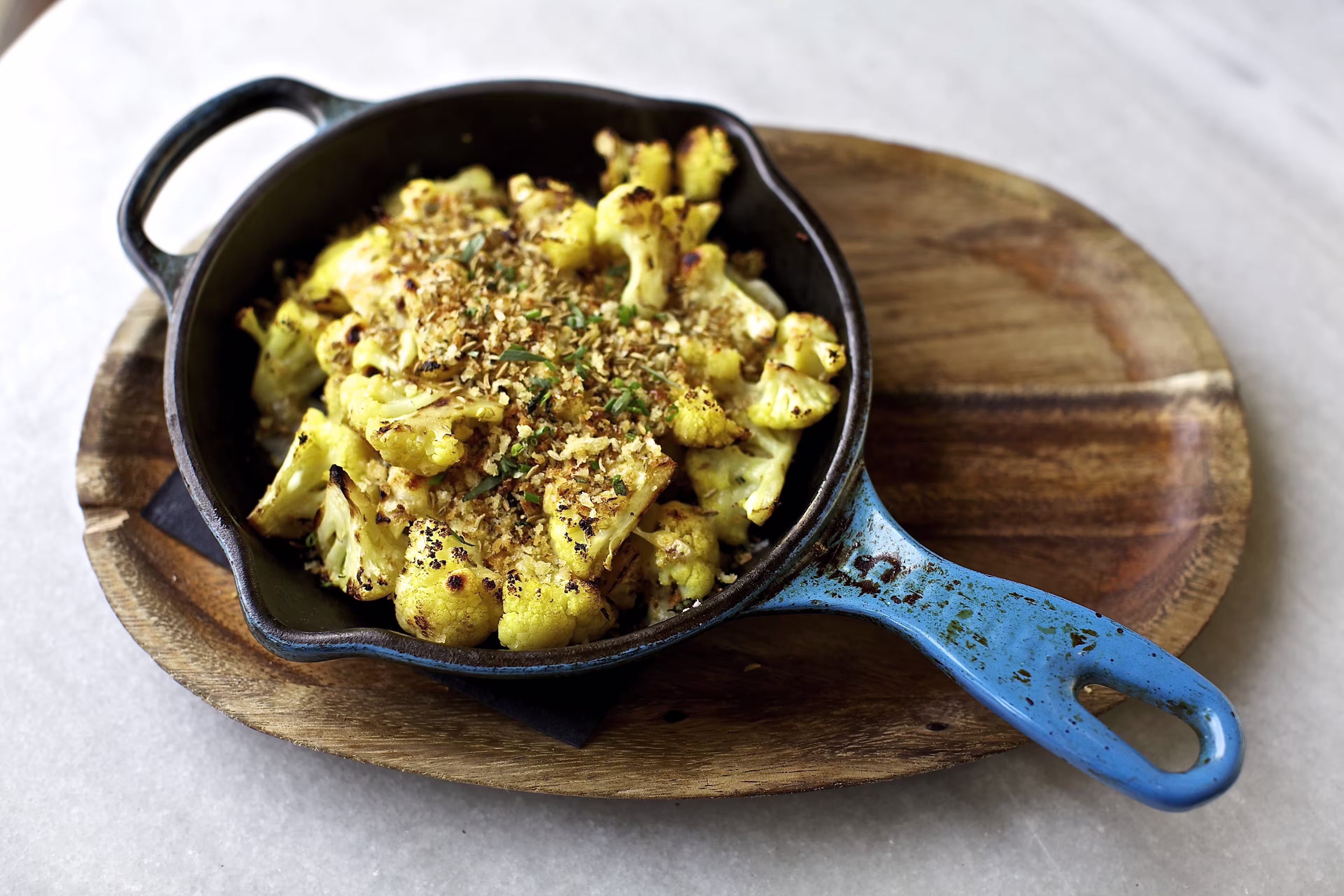 there is a blue skillet with a cooked dish of food on it