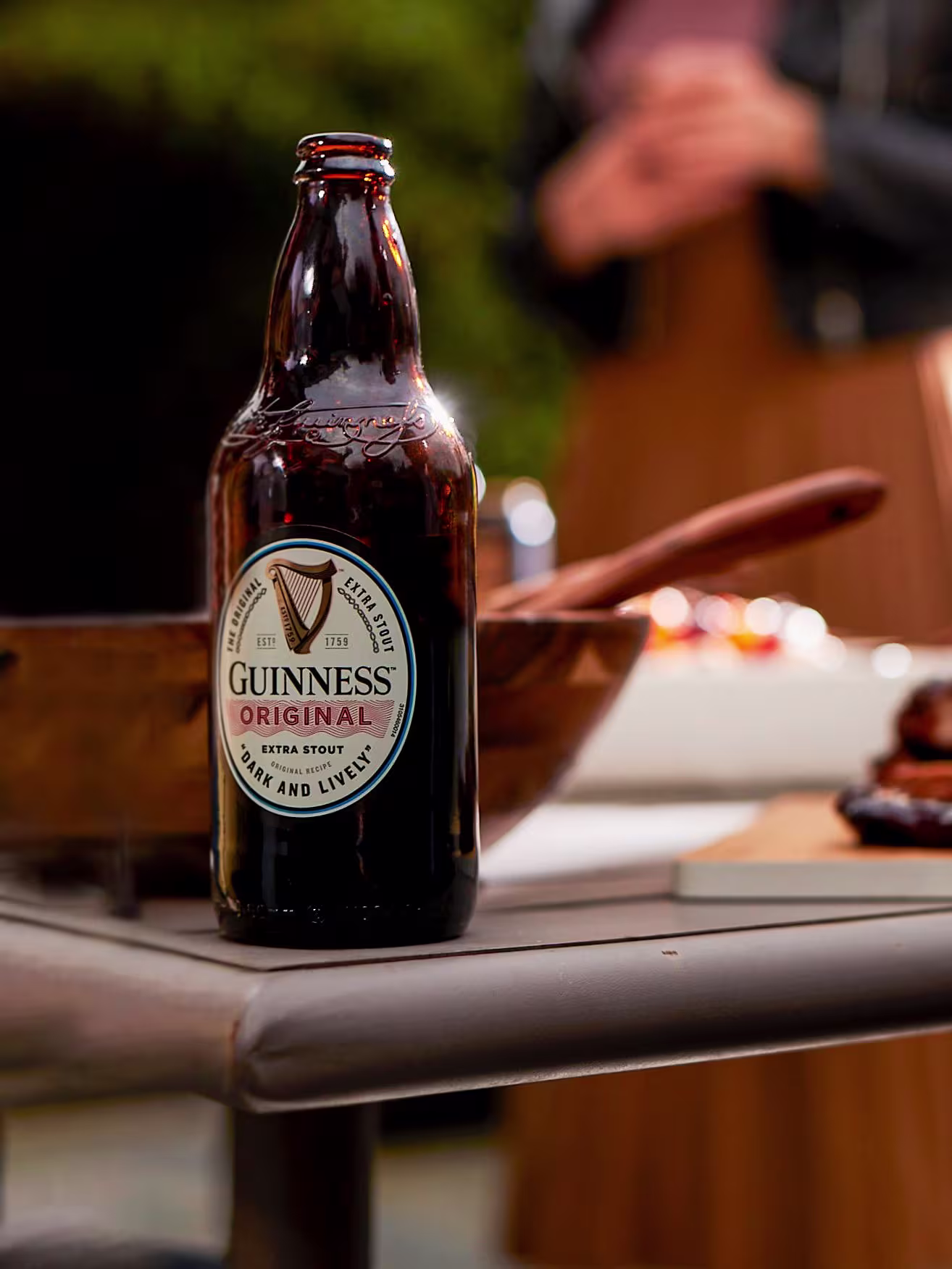 there is a bottle of beer sitting on a table with a wooden spoon